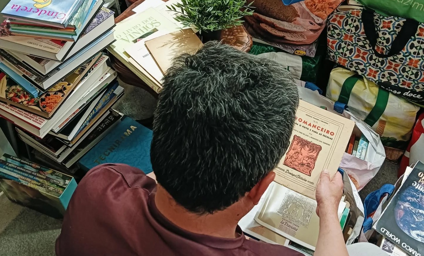 João Méndez Fernandes a avaliar um acervo de livros no escritório do Manuseado